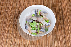 Sliced smoked Atlantic mackerel in bowl on bamboo table mat