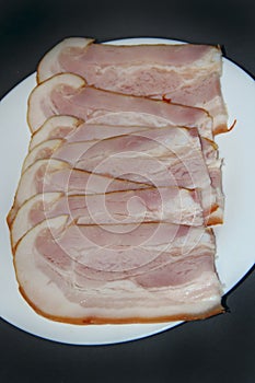 Sliced smoked meat on white plate. Food appetizer concept