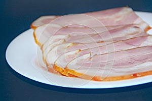 Sliced smoked meat on white plate. Food appetizer concept