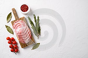 Sliced smoked sausage, on white stone table background, top view flat lay, with copy space for text