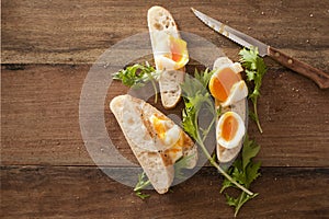 Sliced soft boiled eggs on fresh baguette