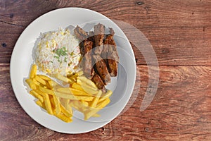Sliced steak with rice and fries sides photo