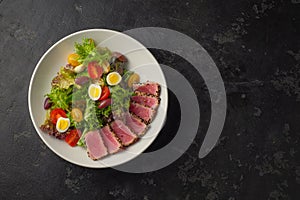 Sliced Steak of tuna in sesame and a salad of fresh vegetables and quail eggs.