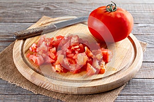 Sliced tomato on a cutting board for making lentil soup. Step by step