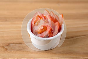 Sliced tomato served in a white bowl. Snack, appetizer, healthy raw organic vegetables. Copy space banner.