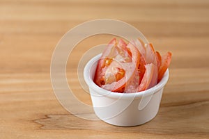 Sliced tomato served in a white bowl. Snack, appetizer, healthy raw organic vegetables. Copy space banner.
