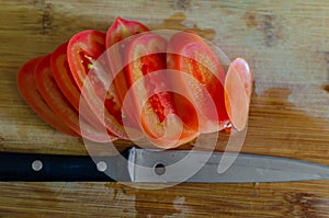 Sliced tomatoe and knife photo