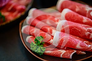 Sliced topside wagyu beef for yakiniku on plate on black background, Premium Japanese meat photo