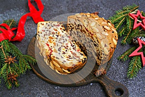 Sliced traditional Scottish Christmas Dundee fruit cake with dried fruit mix, garnished with peeled almonds on a wooden board
