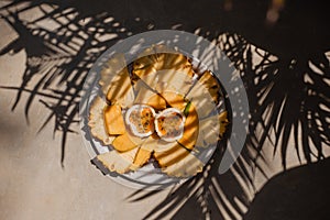 sliced tropical fruits on a white plate.