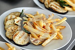 Sliced up vegetables with fries on the table