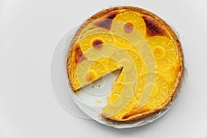 Sliced upside down pineapple cake on white table. Summer tropical dessert. Top view. Copy space