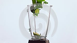 Sliced vegetable fall blender in super slow motion closeup. Veggies fruits herbs