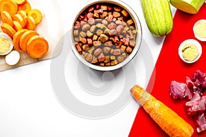 Sliced vegetables and petfood on kitchen table background top vi