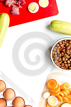 Sliced vegetables and petfood on kitchen table background top view mockup