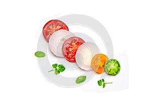 Sliced vegetables tomato and onion and Basil leaves and parsley on white background