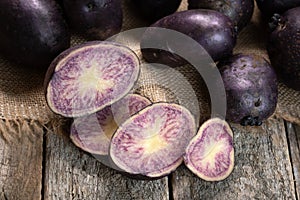 Sliced vitelotte purple potato on the wooden boards and burlap cloth