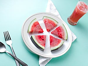 Sliced Watermelon on white plate with spoon and fork stock photo with white background.