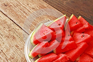 sliced watermelon on white plate and wooden background