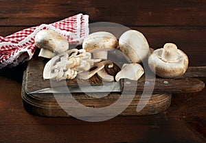 Sliced white mushrooms on a brown wooden board