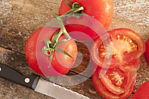Sliced and whole fresh tomatoes on the vine