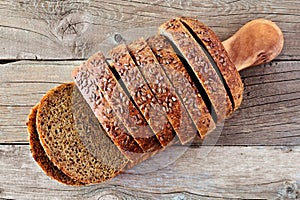 Sliced whole grain bread with flax, above view on wood