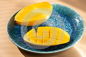 Sliced yellow mango on blue plate and shinning