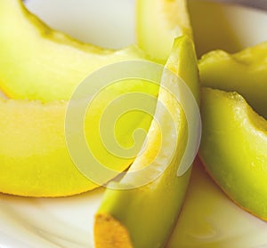 Sliced yellow melon on white plate