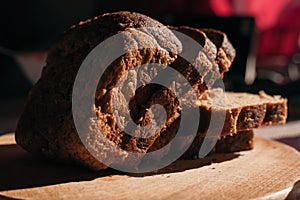 Sliced â€‹â€‹black rye bread on a wooden board. Brick-shaped bread