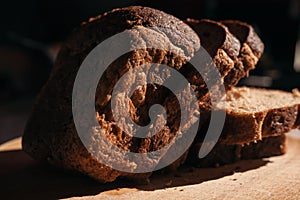 Sliced â€‹â€‹black rye bread on a wooden board. Brick-shaped bread