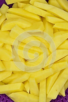 Sliced â€‹â€‹potatoes in purple plastic colander