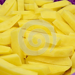 Sliced â€‹â€‹potatoes in purple plastic colander