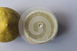 sliced â€‹â€‹whole and half lemons on a white background, one of the fruits that is high in vitamin C
