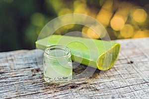 Slices of a aloe vera leaf and a bottle with transparent gel for medicinal purposes, skin treatment and cosmetics, close