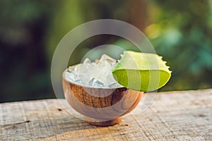 Slices of a aloe vera leaf and a bottle with transparent gel for medicinal purposes, skin treatment and cosmetics, close