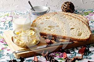 Slices of artisan bread, glass bowl with margarine photo