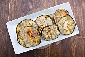 Slices of aubergine on wood from above