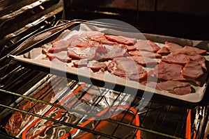 Slices of back bacon baking in the oven.