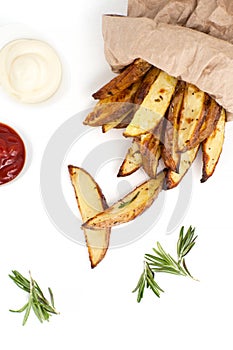 Slices of baked potato with rosemary, tomato sauce and mayonnaise on a white background..