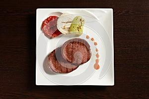 Slices of beef sausage bbq with grilled vegetables, top view