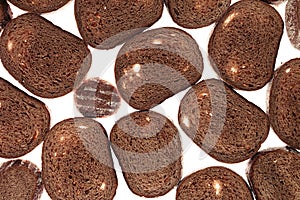 Slices of black rye bread on a white background. Food background.