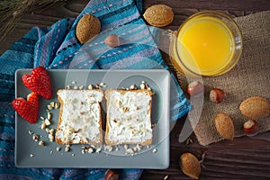 Slices of bread with cream cheese, strawberries and juice photo