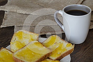Slices of bread with linden honey on a dark wooden background