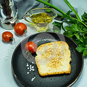 Slices of bread, sandwiches, red tomatoes, salt shaker, greens. The concept of making breakfast or a snack from organic farm