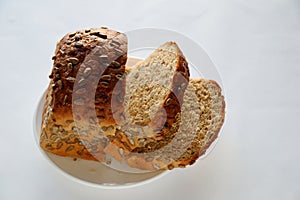 Slices of bread from several grains of sunflower and pumpkin and flax seeds in a white plate