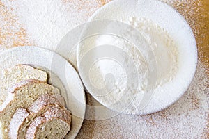 Slices of bread and wheat flour in a white plate on the table