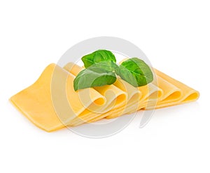 Slices of cheese with fresh basil leaves close-up isolated on a white background.