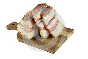 Slices of chopped salted pork fat lie on a wooden plank. Isolated on a white background.