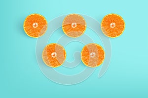Slices of delicious oranges on bright blue background.