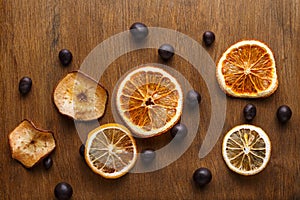 Slices of dried fruits on wooden board background
